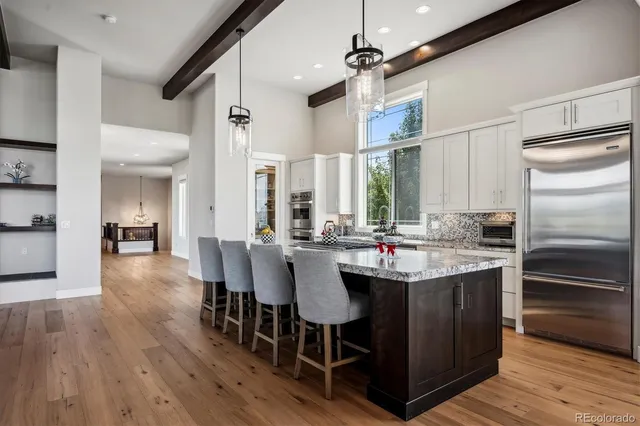 a kitchen with kitchen island granite countertop a sink counter and chairs