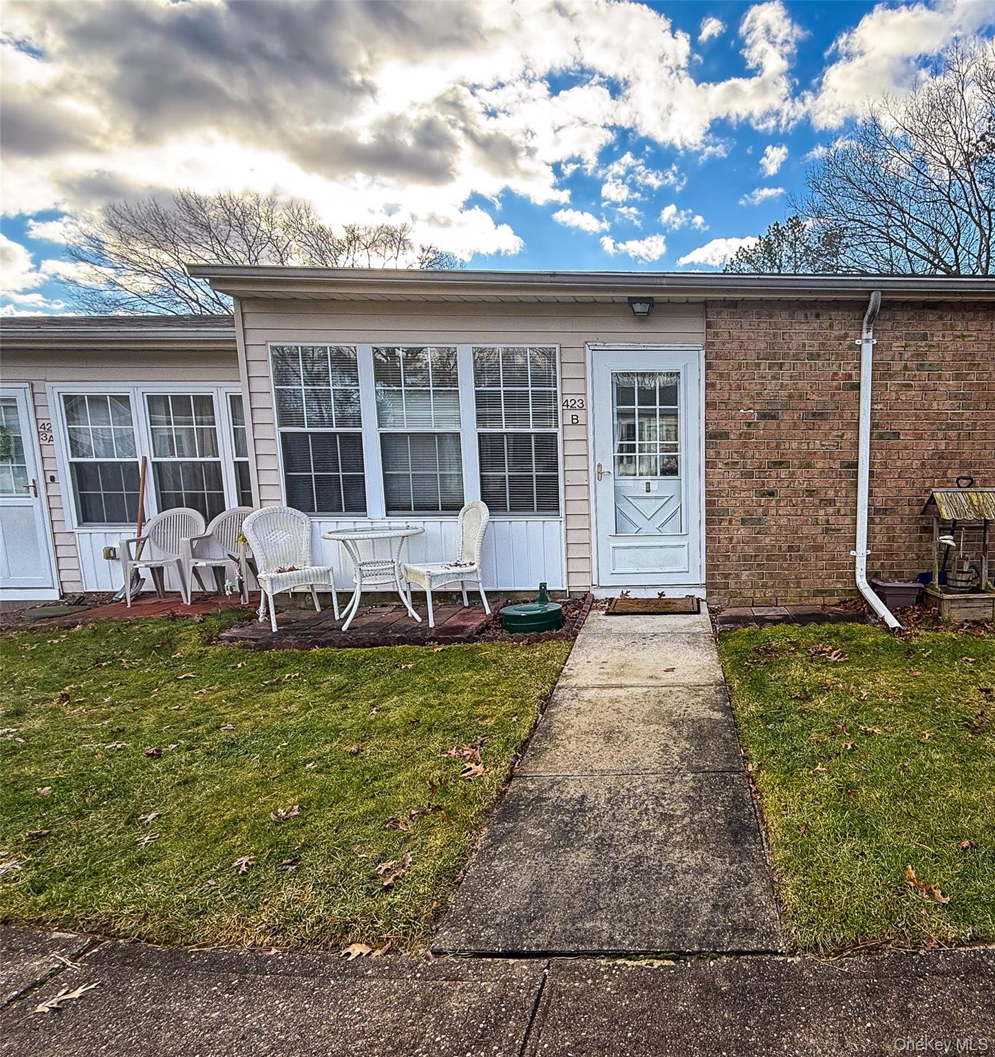 Entrance to property featuring a yard and brick siding