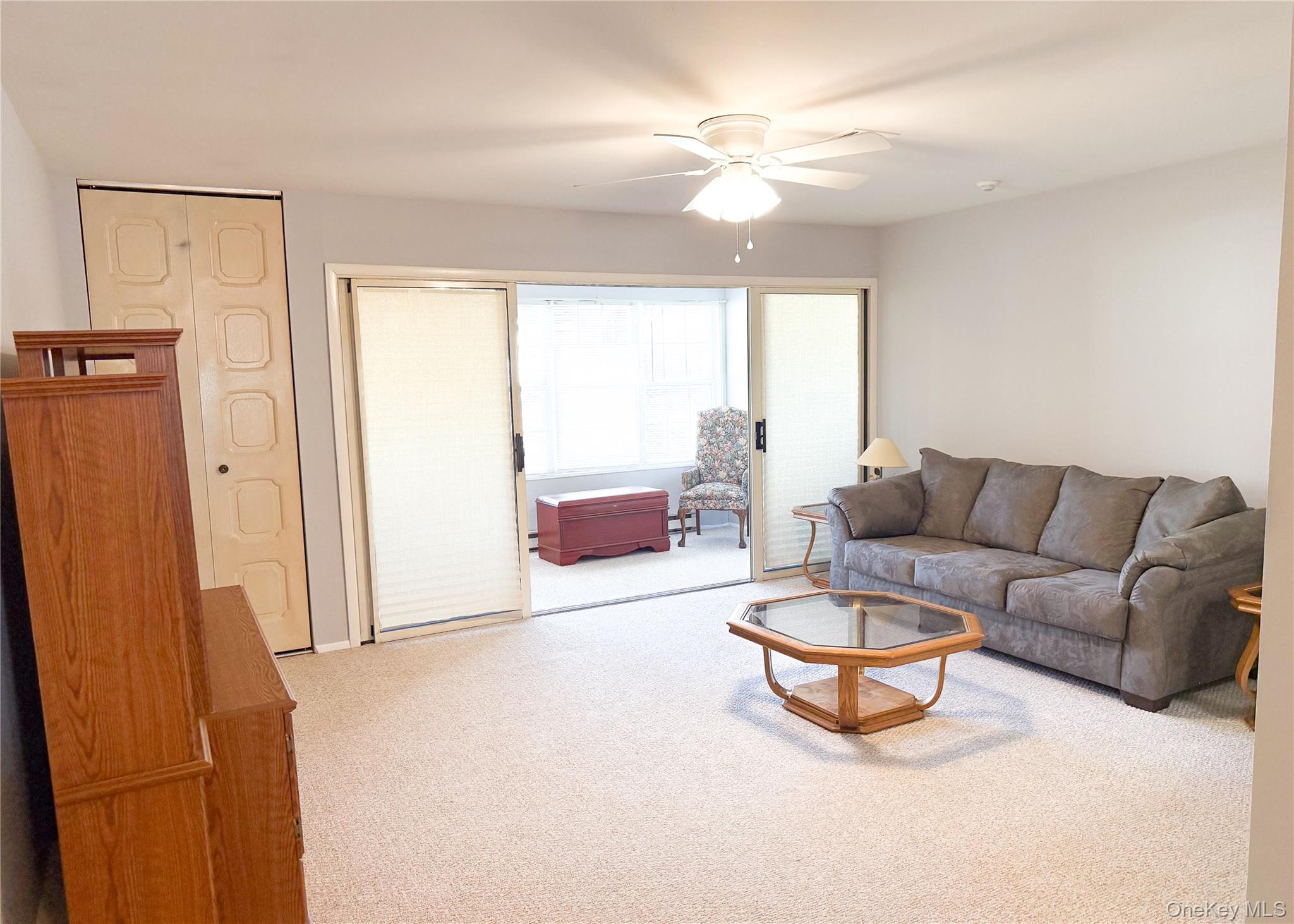 423 Woodbridge Drive, Unit B Ridge, NY 11961 - Photo 4 of 13 Living area featuring light colored carpet and ceiling fan