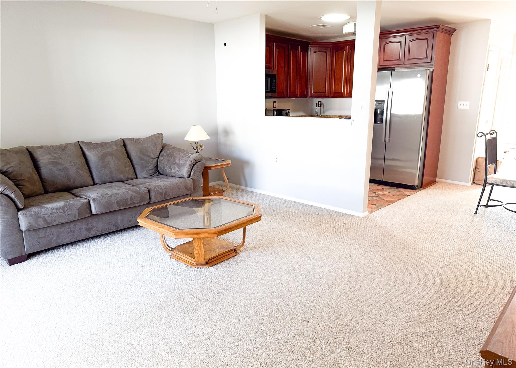 423 Woodbridge Drive, Unit B Ridge, NY 11961 - Photo 6 of 13 Living room featuring light colored carpet and baseboards