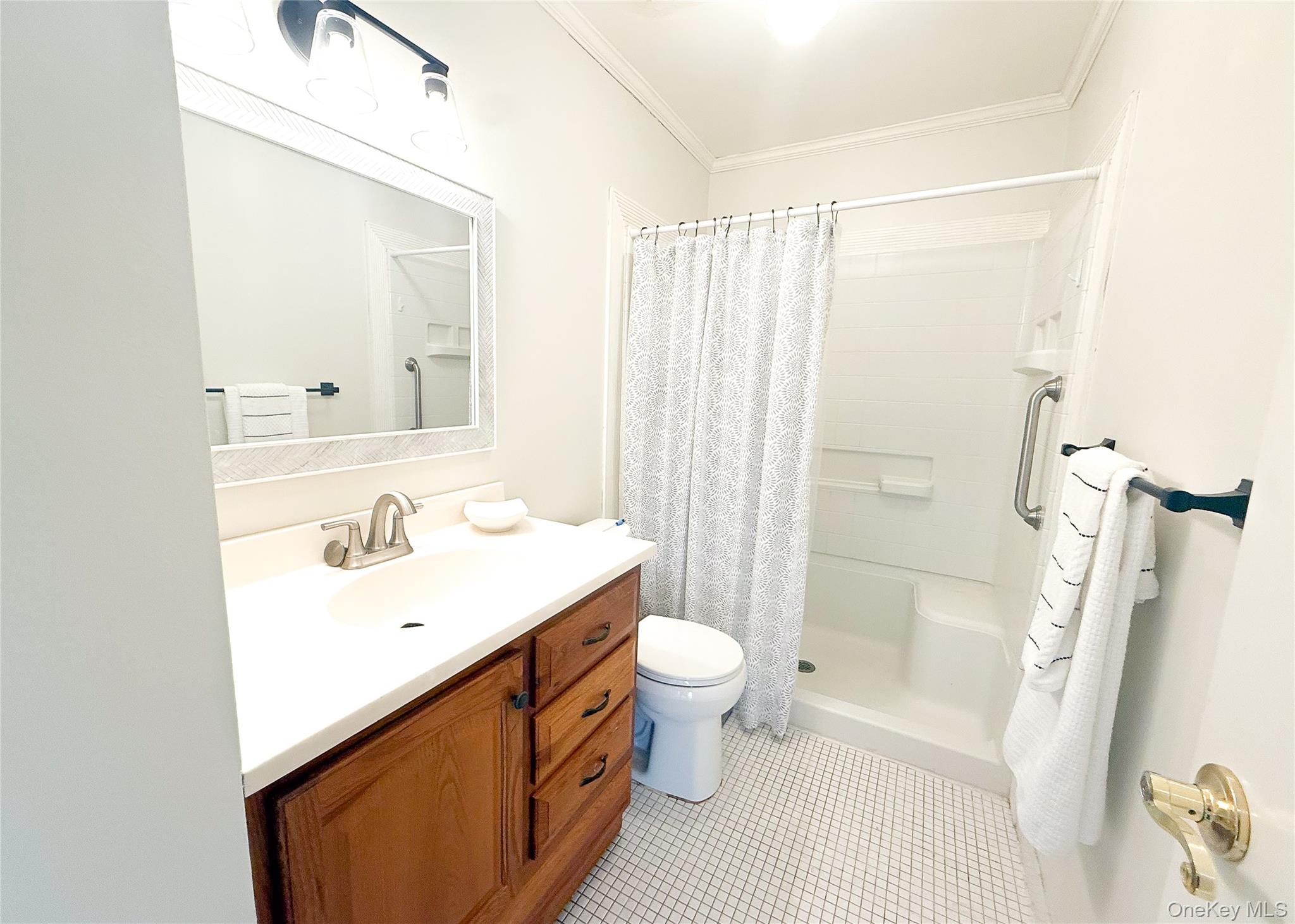 423 Woodbridge Drive, Unit B Ridge, NY 11961 - Photo 10 of 13 Full bathroom featuring a shower stall, vanity, ornamental molding, and light tile patterned floors
