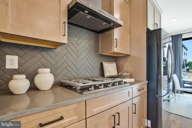 a kitchen with stainless steel appliances granite countertop a sink a stove and a refrigerator