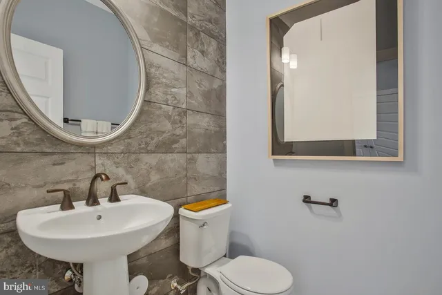 a bathroom with a sink toilet and mirror