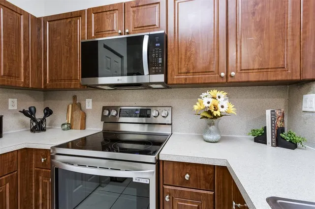 a kitchen with stainless steel appliances granite countertop a sink a stove and cabinets