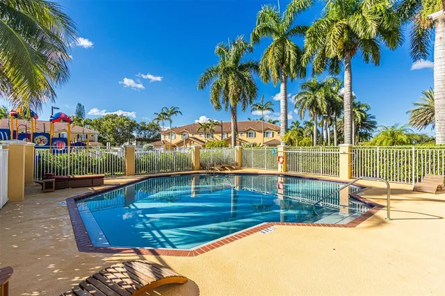 a view of a park with a slide and potted plants