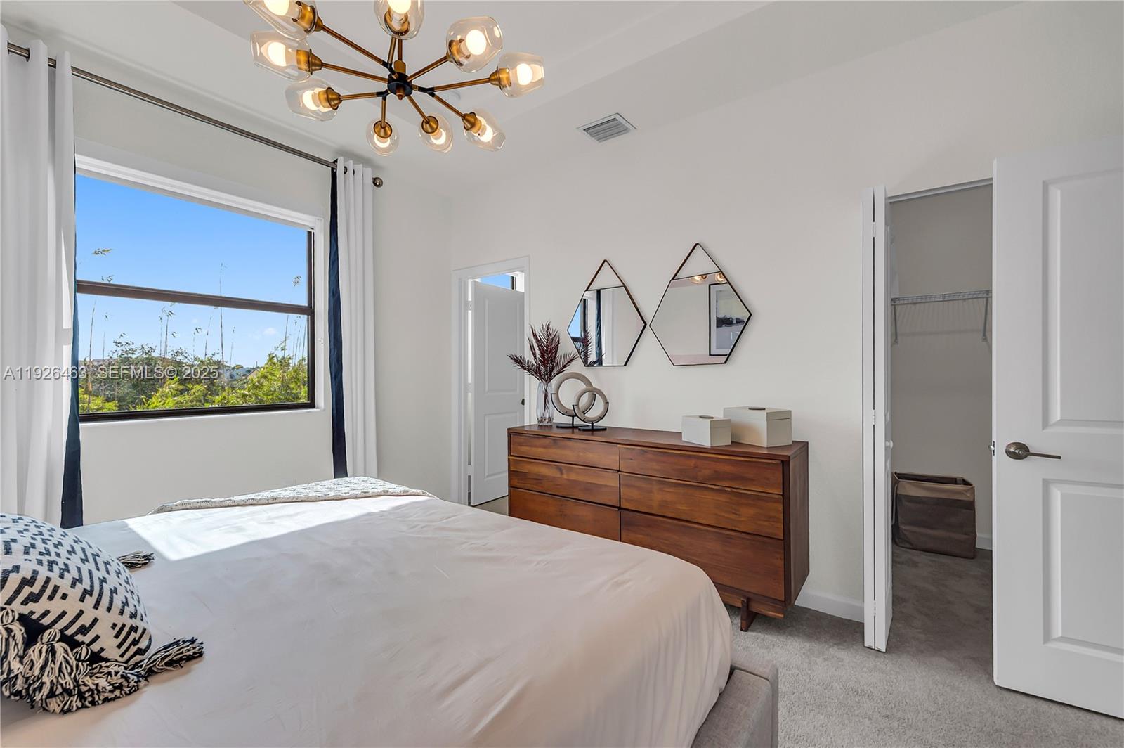 12976 Southwest 233rd Terrace Homestead, FL 33032 - Photo 19 of 27 a bedroom with a bed and a chandelier