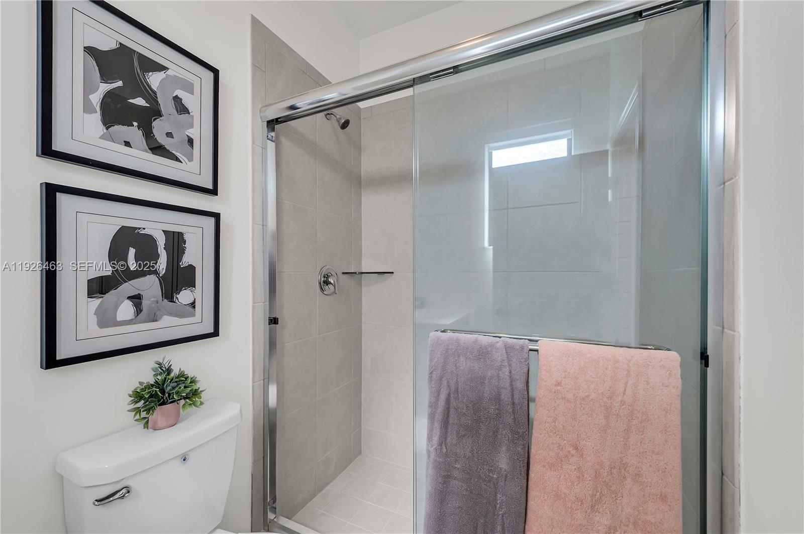 12976 Southwest 233rd Terrace Homestead, FL 33032 - Photo 22 of 27 a bathroom with a painting on the wall and a shower