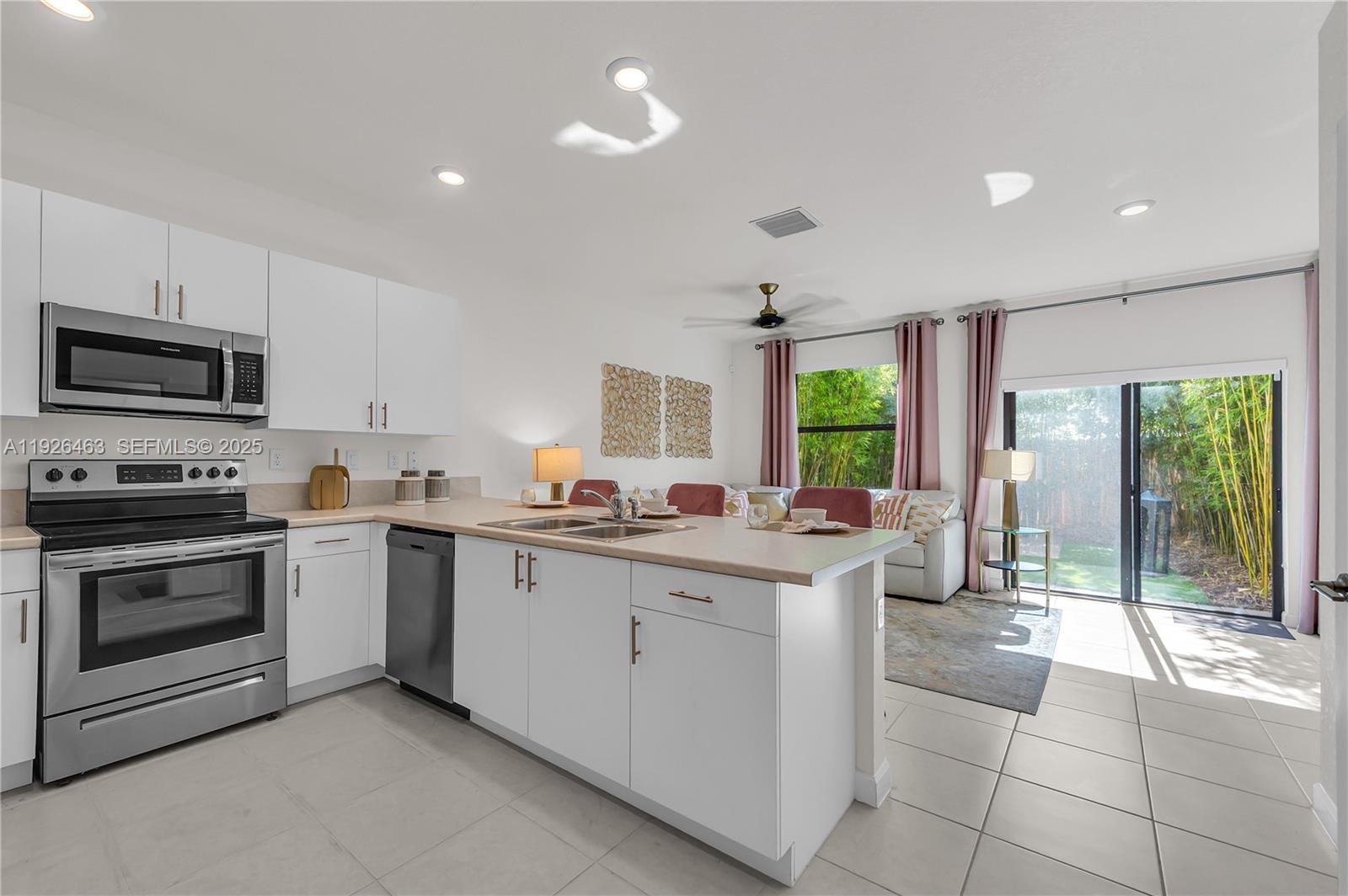 12976 Southwest 233rd Terrace Homestead, FL 33032 - Photo 7 of 27 a kitchen with a sink cabinets and stainless steel appliances
