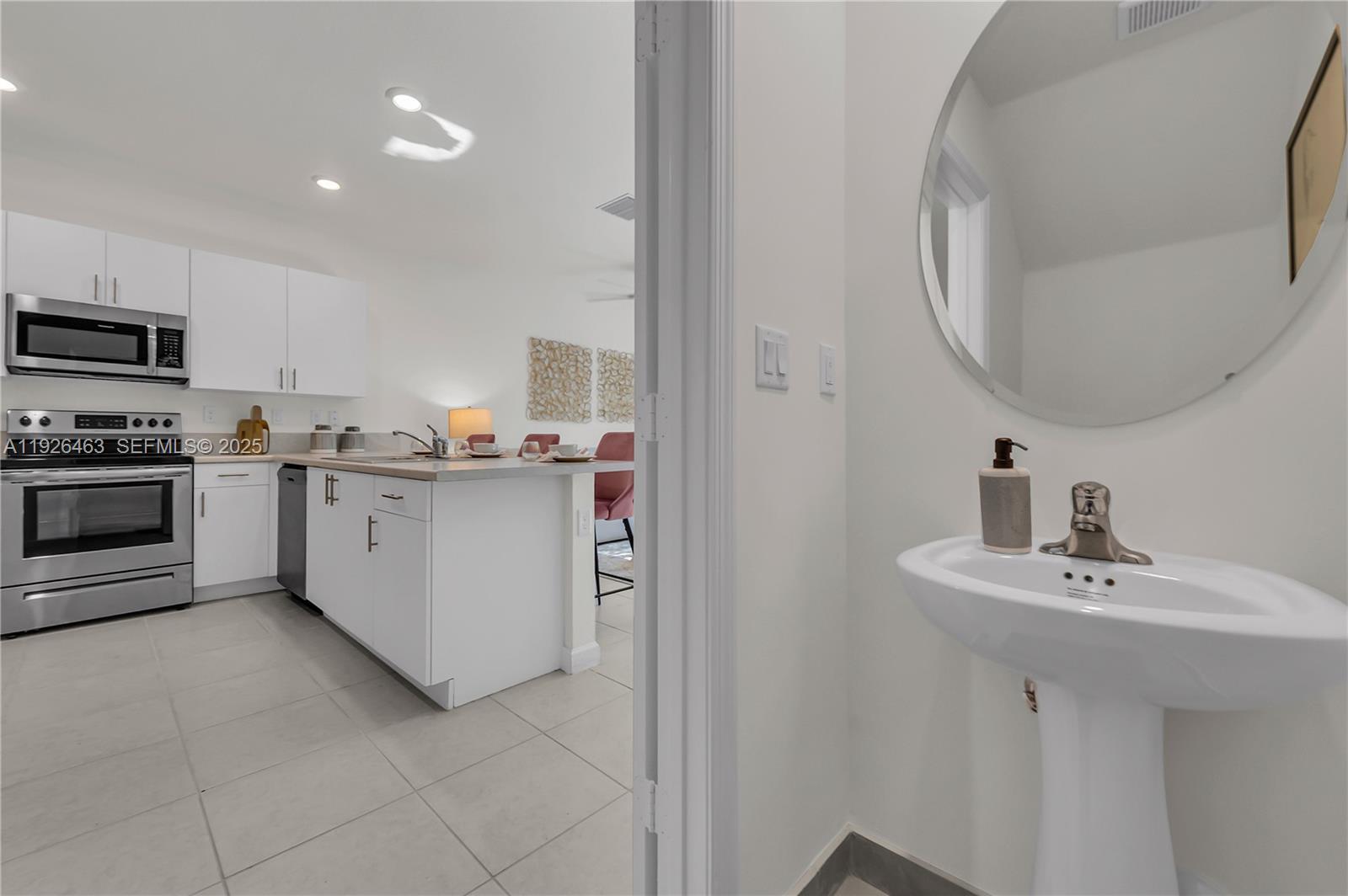 12976 Southwest 233rd Terrace Homestead, FL 33032 - Photo 9 of 27 a kitchen with a sink stainless steel appliances and white cabinets