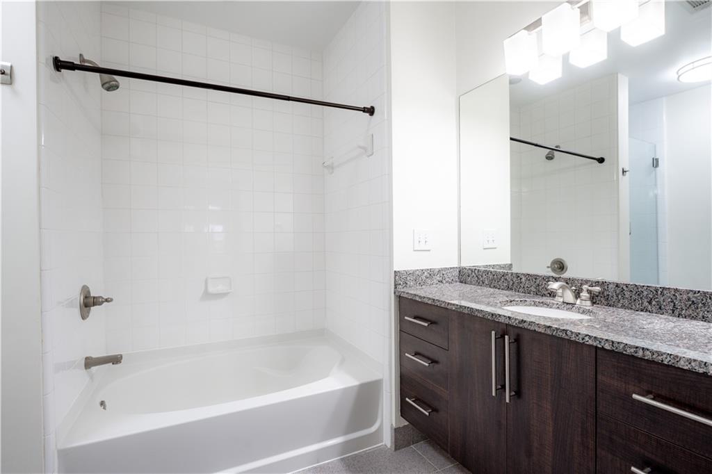 1221 Caroline Street Northeast, Unit 208 Atlanta, GA 30307 - Photo 13 of 26 a bathroom with a granite countertop sink mirror toilet and bathtub