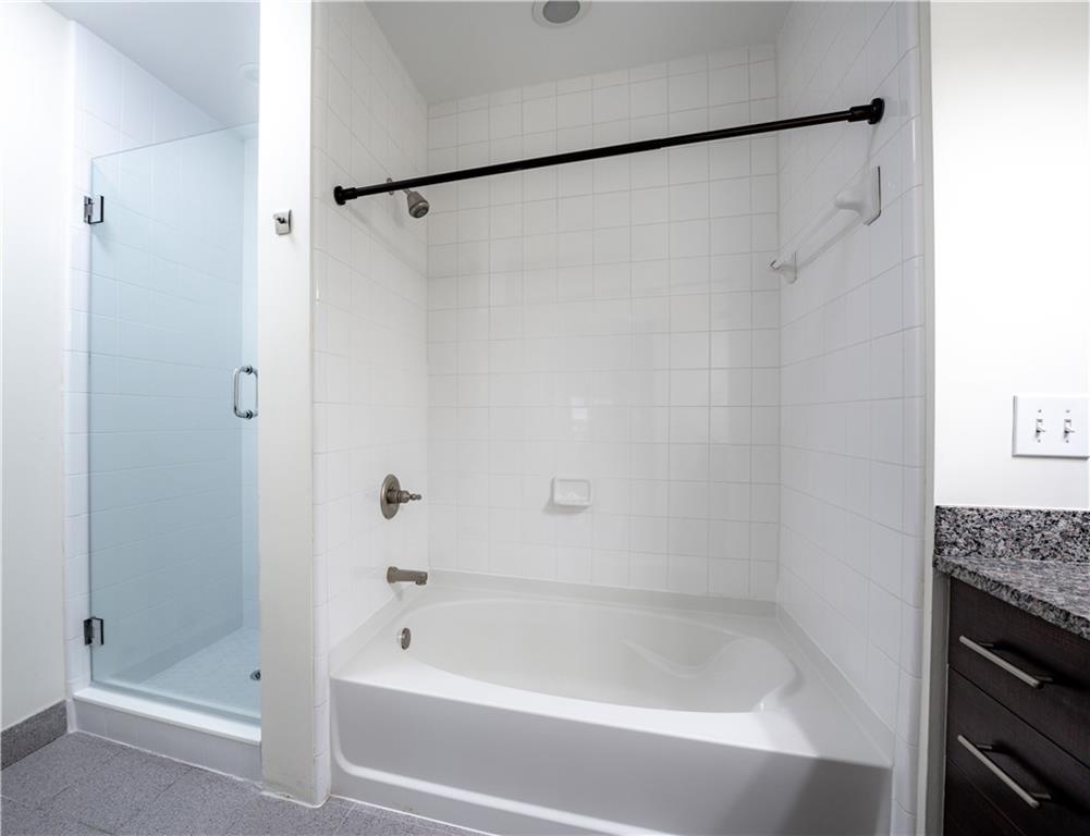 1221 Caroline Street Northeast, Unit 208 Atlanta, GA 30307 - Photo 15 of 26 a bathroom with a shower and a bath tub