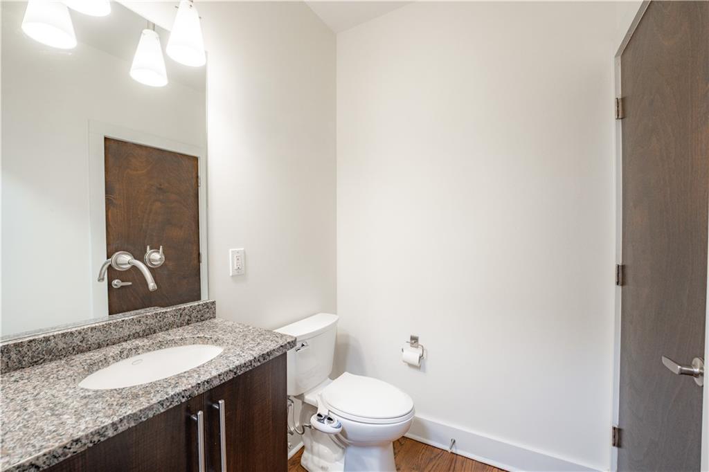 1221 Caroline Street Northeast, Unit 208 Atlanta, GA 30307 - Photo 16 of 26 a bathroom with a granite countertop sink and a toilet