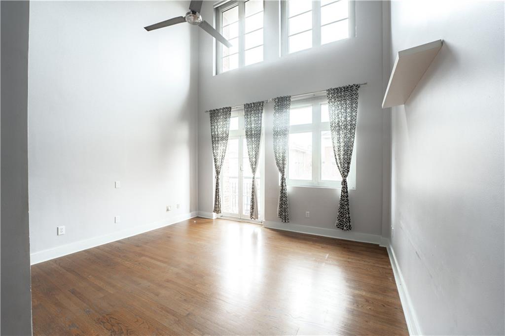 1221 Caroline Street Northeast, Unit 208 Atlanta, GA 30307 - Photo 9 of 26 an empty room with wooden floor and windows