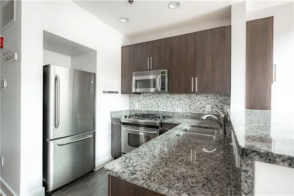 a kitchen with stainless steel appliances granite countertop a stove and a microwave