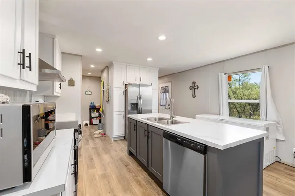 a kitchen with stainless steel appliances a sink stove and refrigerator