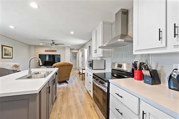 a kitchen with stainless steel appliances sink stove refrigerator and cabinets