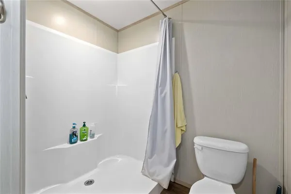a bathroom with a toilet and a shower