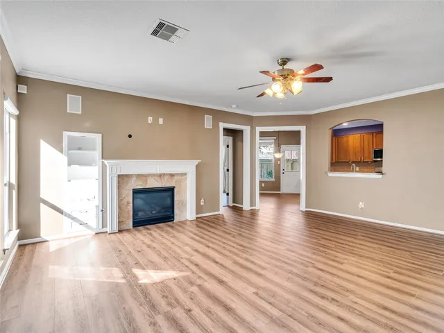 a view of an empty room with a fireplace and a window