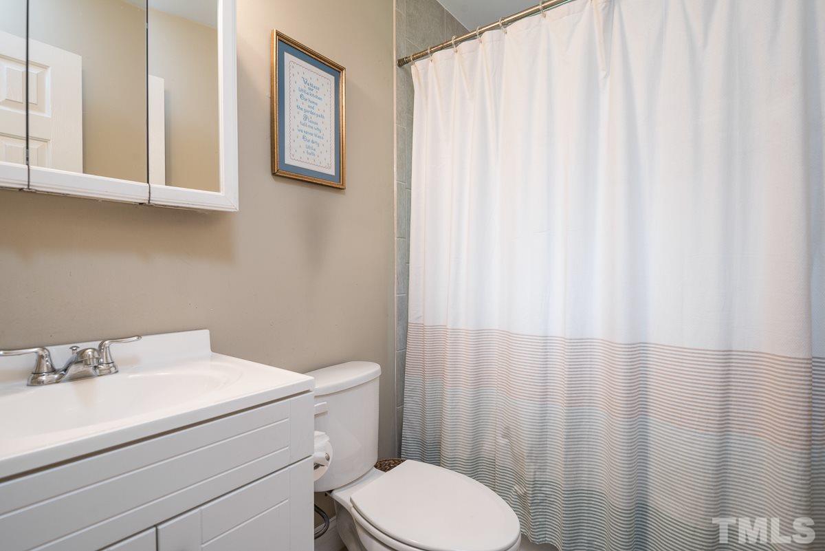 2212 Rumson Road Raleigh, NC 27610 - Photo 13 of 19 a bathroom with a sink a toilet and shower curtain