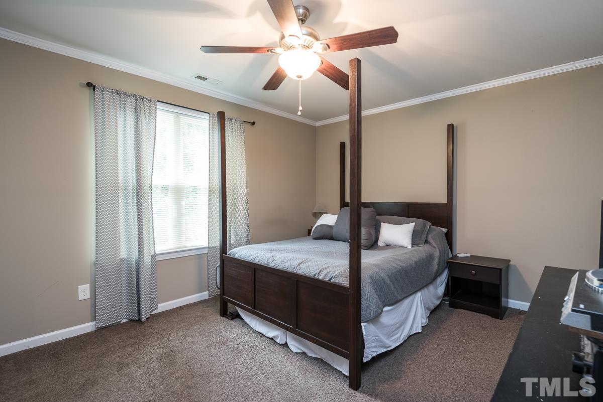 2212 Rumson Road Raleigh, NC 27610 - Photo 16 of 19 a bedroom with a bed and a chandelier