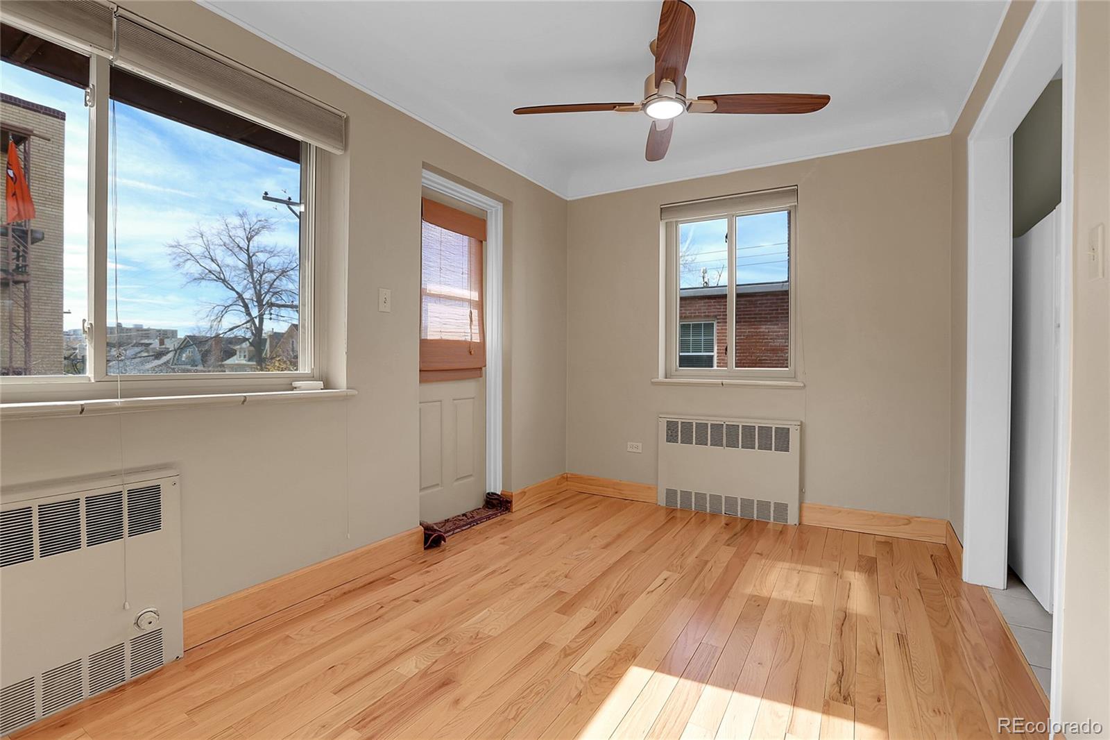 1175 Emerson Street, Unit 202 Denver, CO 80218 - Photo 10 of 31 a view of an empty room with wooden floor and a window