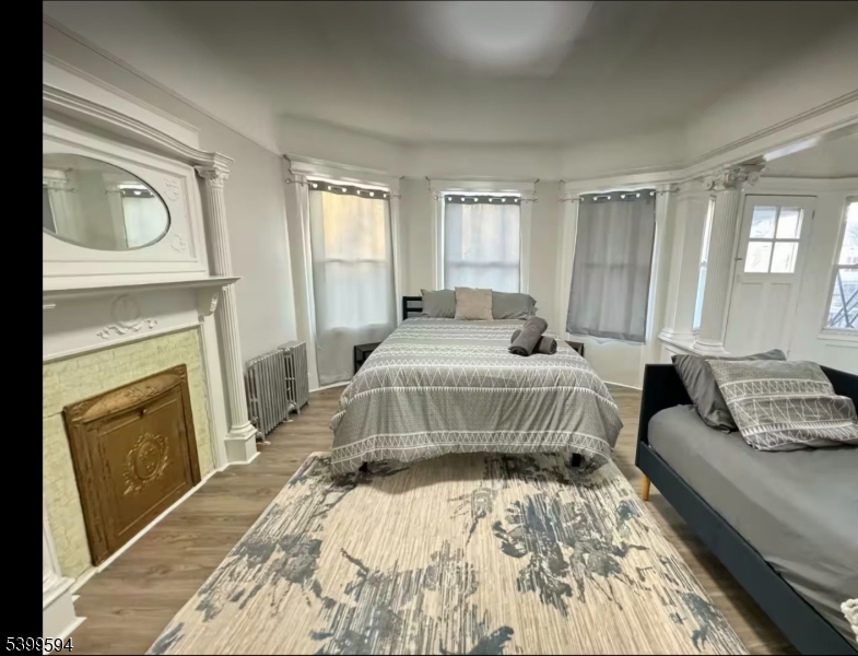 854 South 15th Street, Unit 2 Newark, NJ 07108 - Photo 8 of 9 a bedroom with a bed a fireplace and windows
