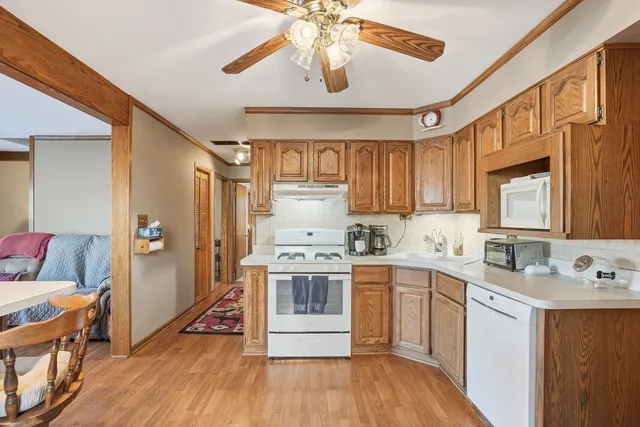 a kitchen with stainless steel appliances granite countertop a sink cabinets and wooden floor