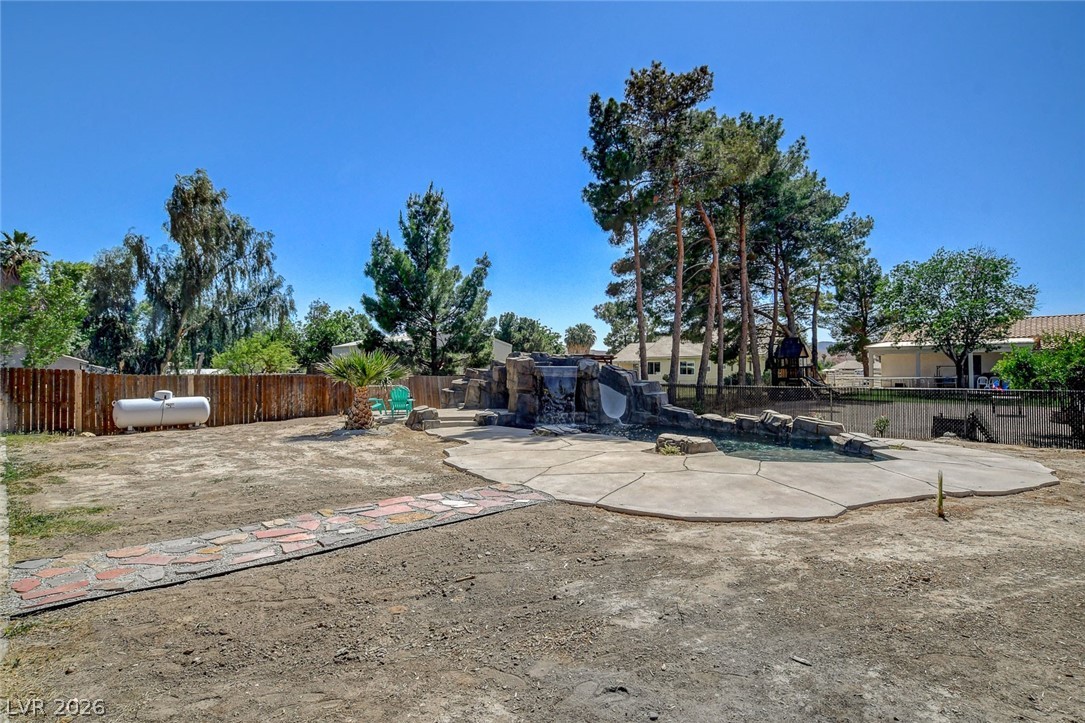 3765 Berkeley Street Logandale, NV 89021 - Photo 73 of 87 This spacious yard features a private pool with a waterfall, perfect for outdoor enjoyment.
