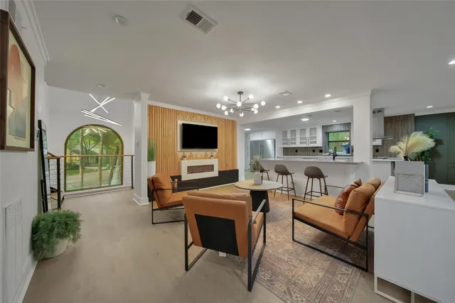 a living room with furniture a flat screen tv and a large window