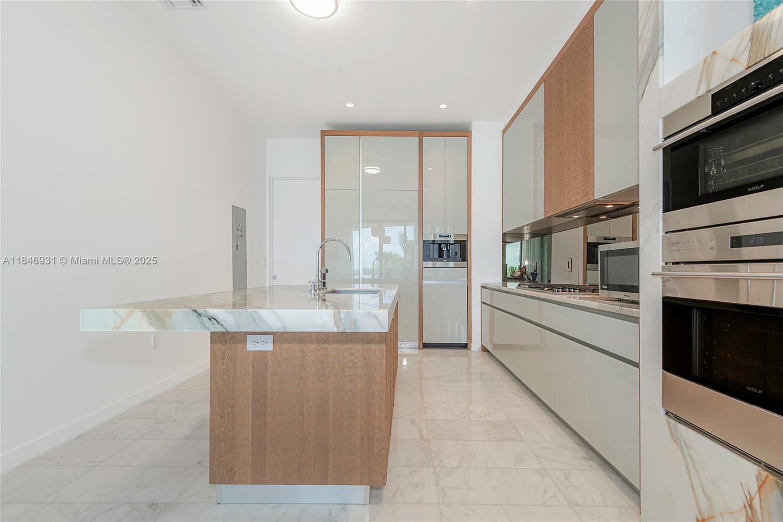 2821 South Bayshore Drive, Unit 7B Coconut Grove, FL 33133 - Photo 12 of 35 a kitchen with stainless steel appliances kitchen island granite countertop a refrigerator and a stove top oven