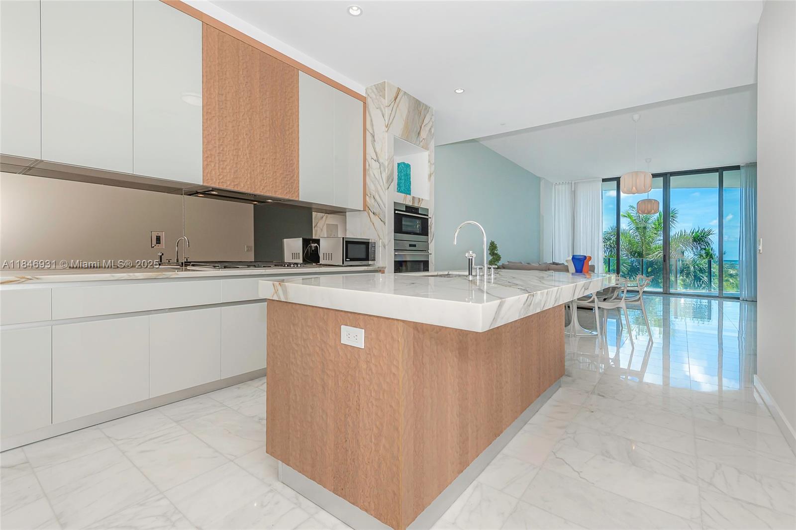 2821 South Bayshore Drive, Unit 7B Coconut Grove, FL 33133 - Photo 13 of 35 a kitchen with stainless steel appliances sink a microwave and cabinets