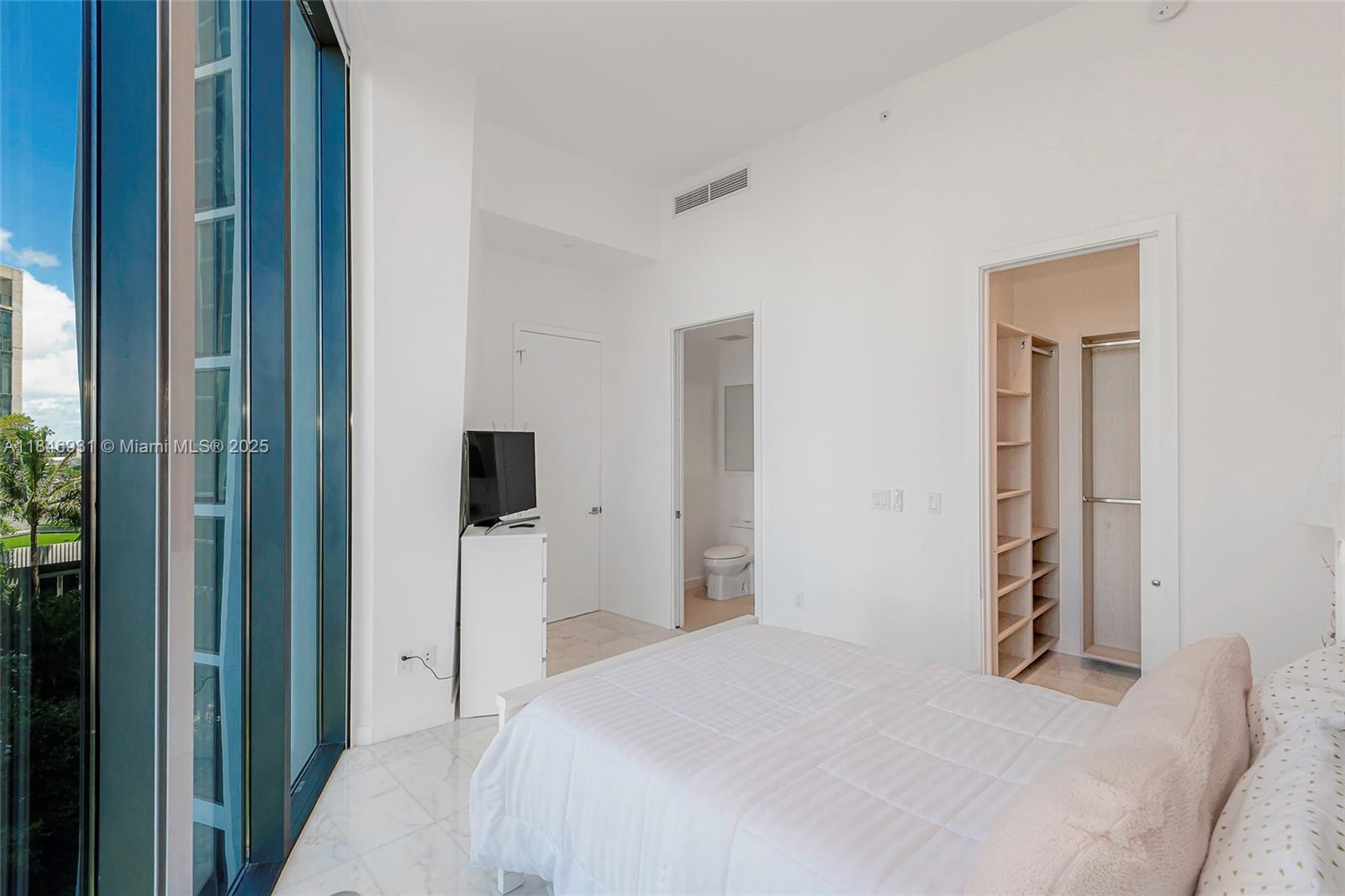 2821 South Bayshore Drive, Unit 7B Coconut Grove, FL 33133 - Photo 19 of 35 a bedroom with a bed and a television