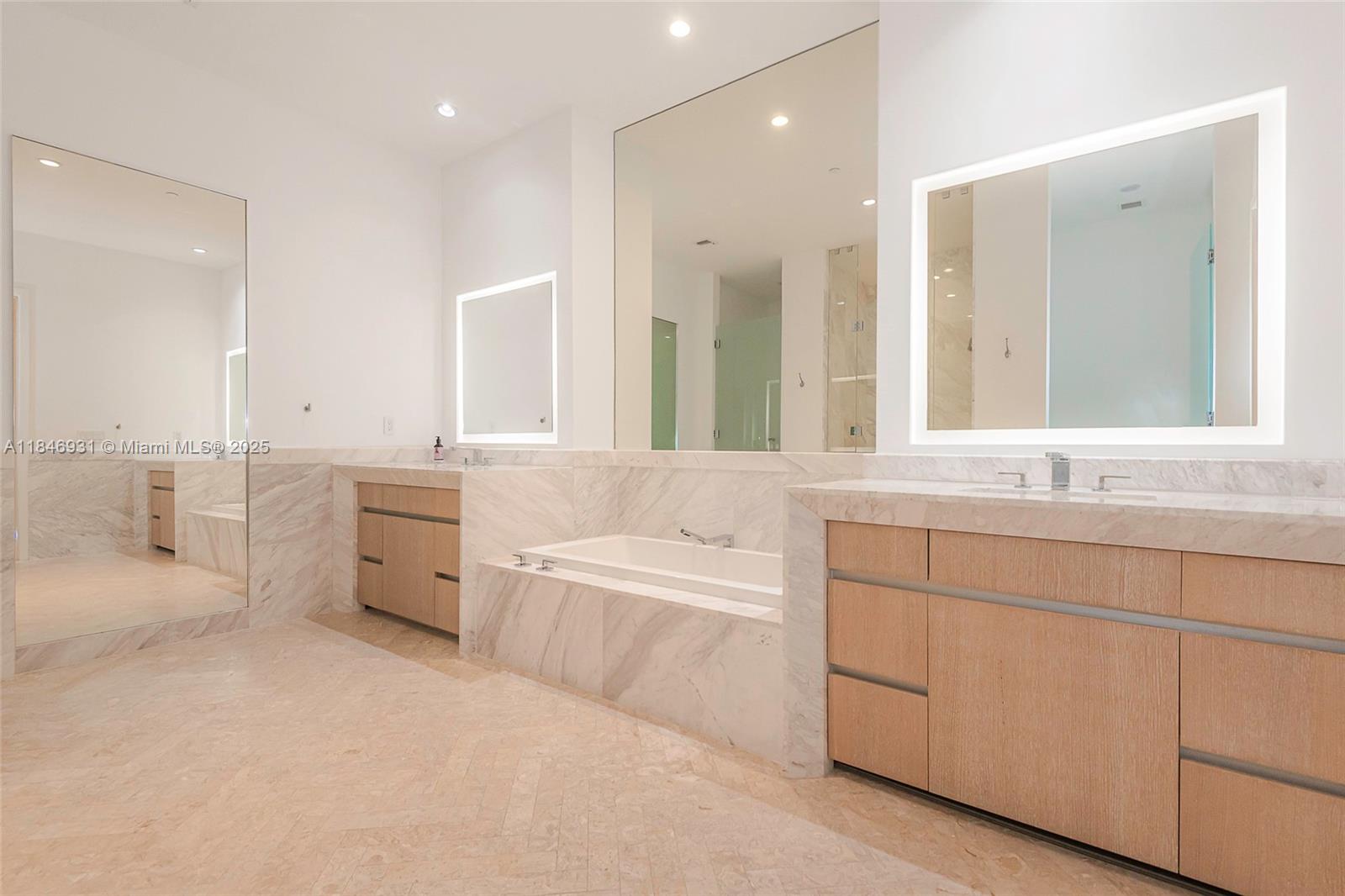 2821 South Bayshore Drive, Unit 7B Coconut Grove, FL 33133 - Photo 29 of 35 a bathroom with a bathtub a double vanity sink a mirror a bathtub and window