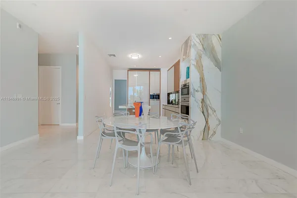 a kitchen with stainless steel appliances kitchen island granite countertop a table and chairs
