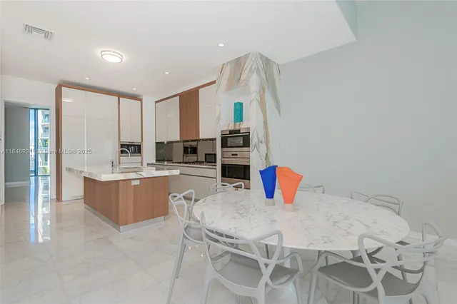 a kitchen with stainless steel appliances kitchen island granite countertop a refrigerator and a stove top oven