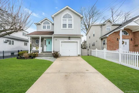 a front view of a house with a yard and trees