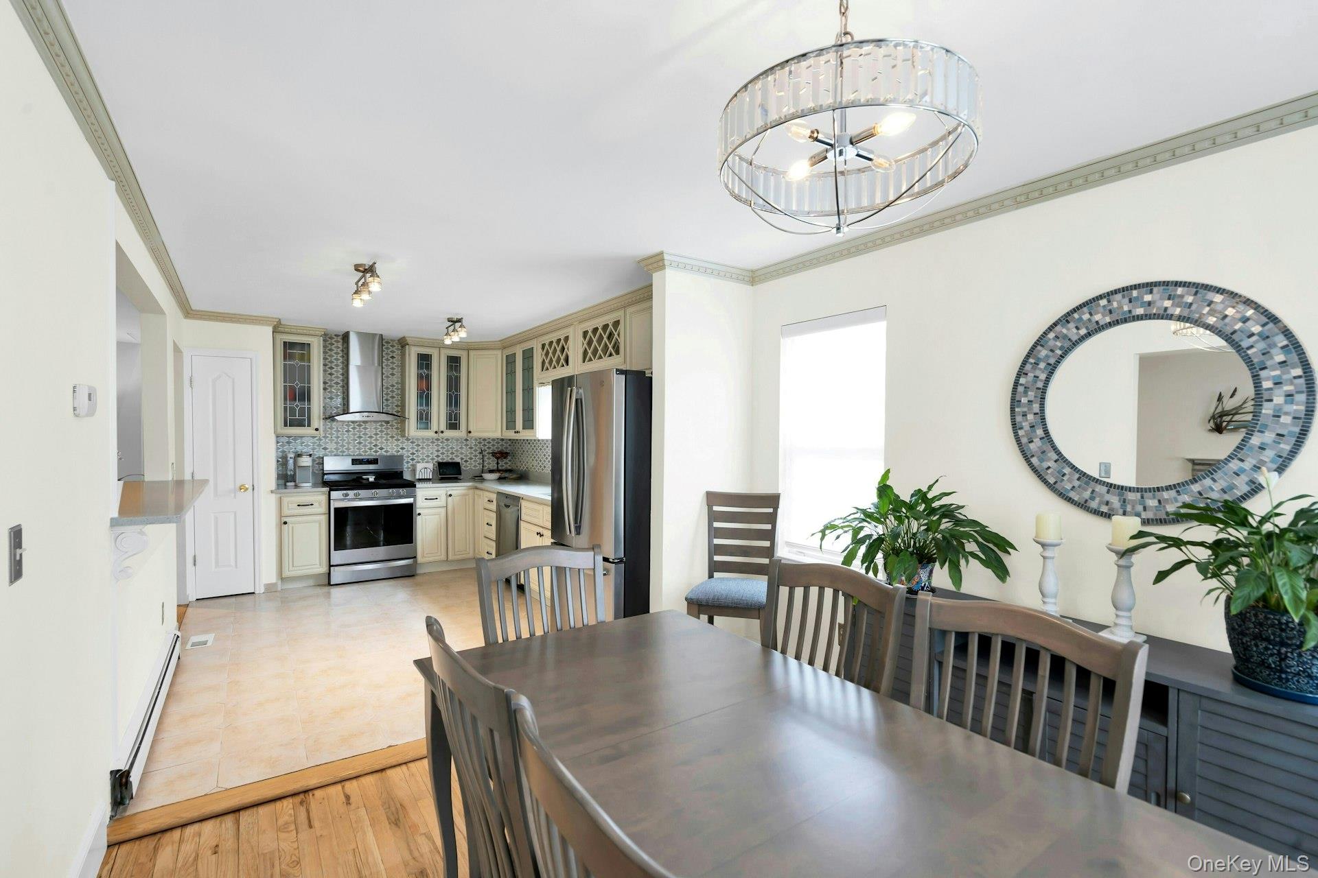 52 Edgewood Road Port Washington, NY 11050 - Photo 11 of 29 a kitchen with stainless steel appliances granite countertop a refrigerator a stove a sink dishwasher a dining table and chairs with wooden floor