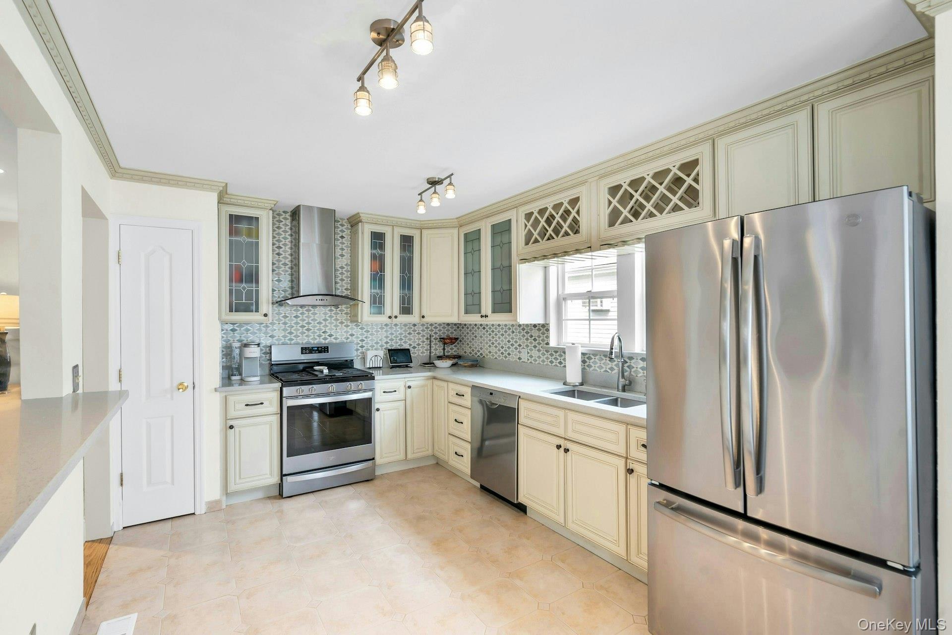 52 Edgewood Road Port Washington, NY 11050 - Photo 12 of 29 a kitchen with stainless steel appliances granite countertop a refrigerator a sink dishwasher a stove with white cabinets