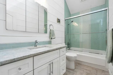 a bathroom with a granite countertop sink a toilet and bathtub
