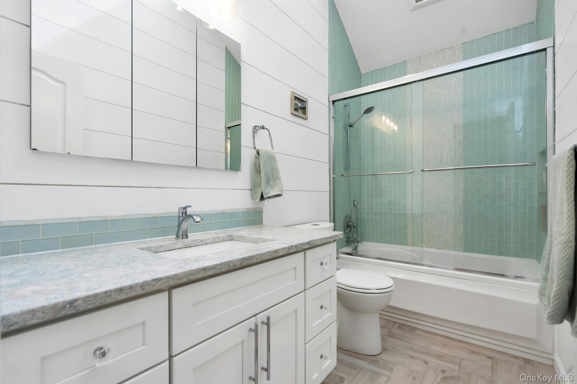 52 Edgewood Road Port Washington, NY 11050 - Photo 17 of 29 a bathroom with a granite countertop sink a toilet and bathtub