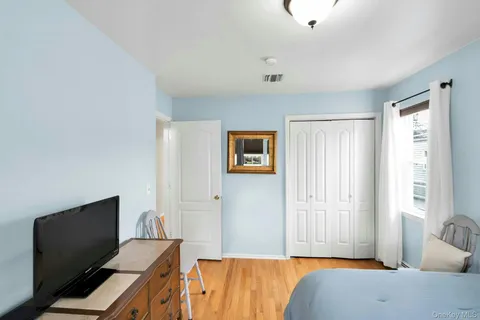 a bedroom with a bed and a computer on the desk