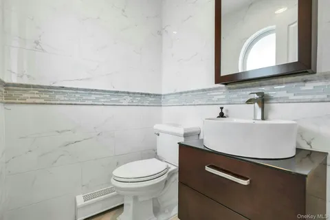 a bathroom with a sink a toilet and a mirror