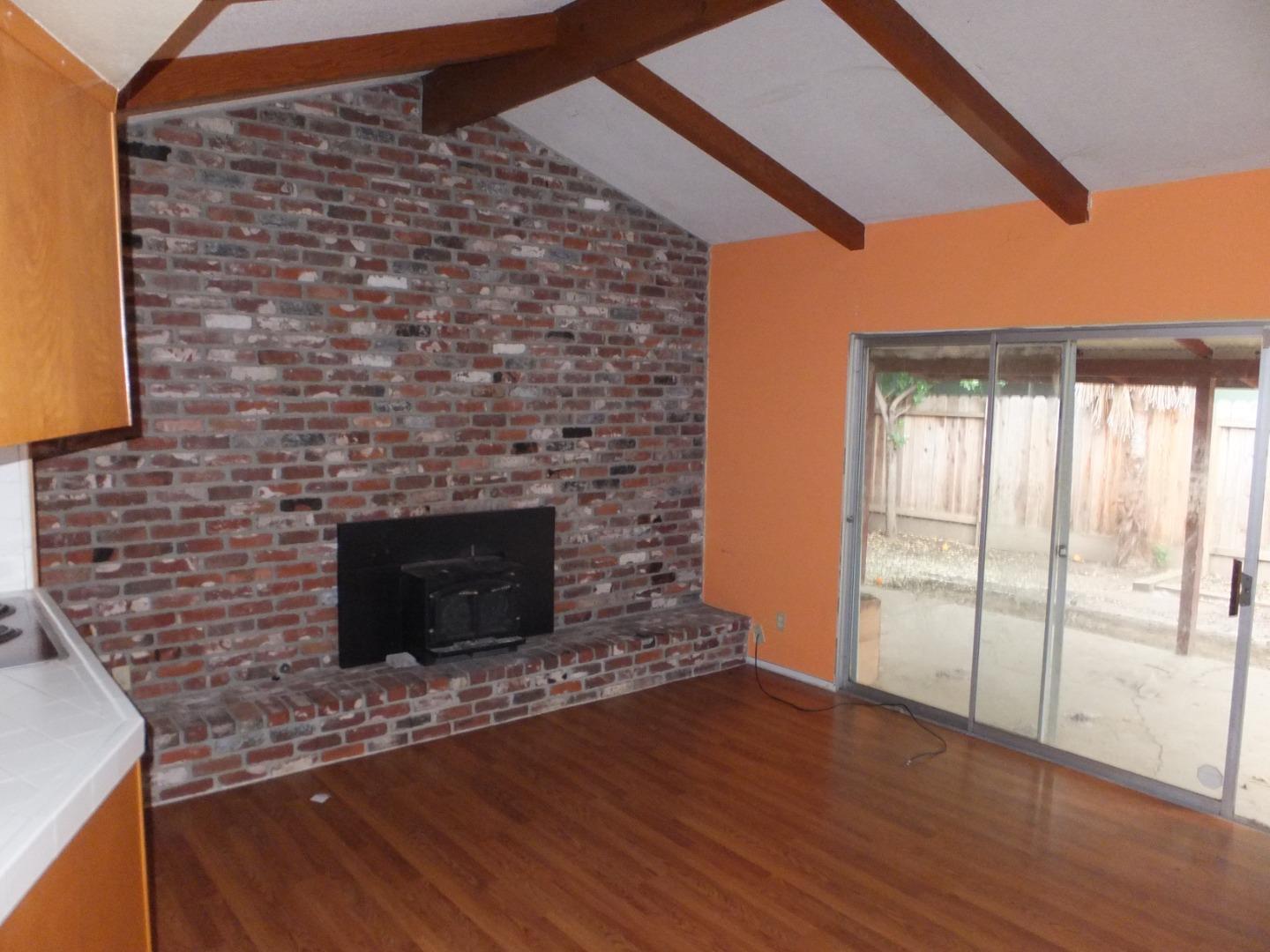 856 Modoc Street Merced, CA 95340 - Photo 7 of 16 a living room with a fireplace and a floor to ceiling window