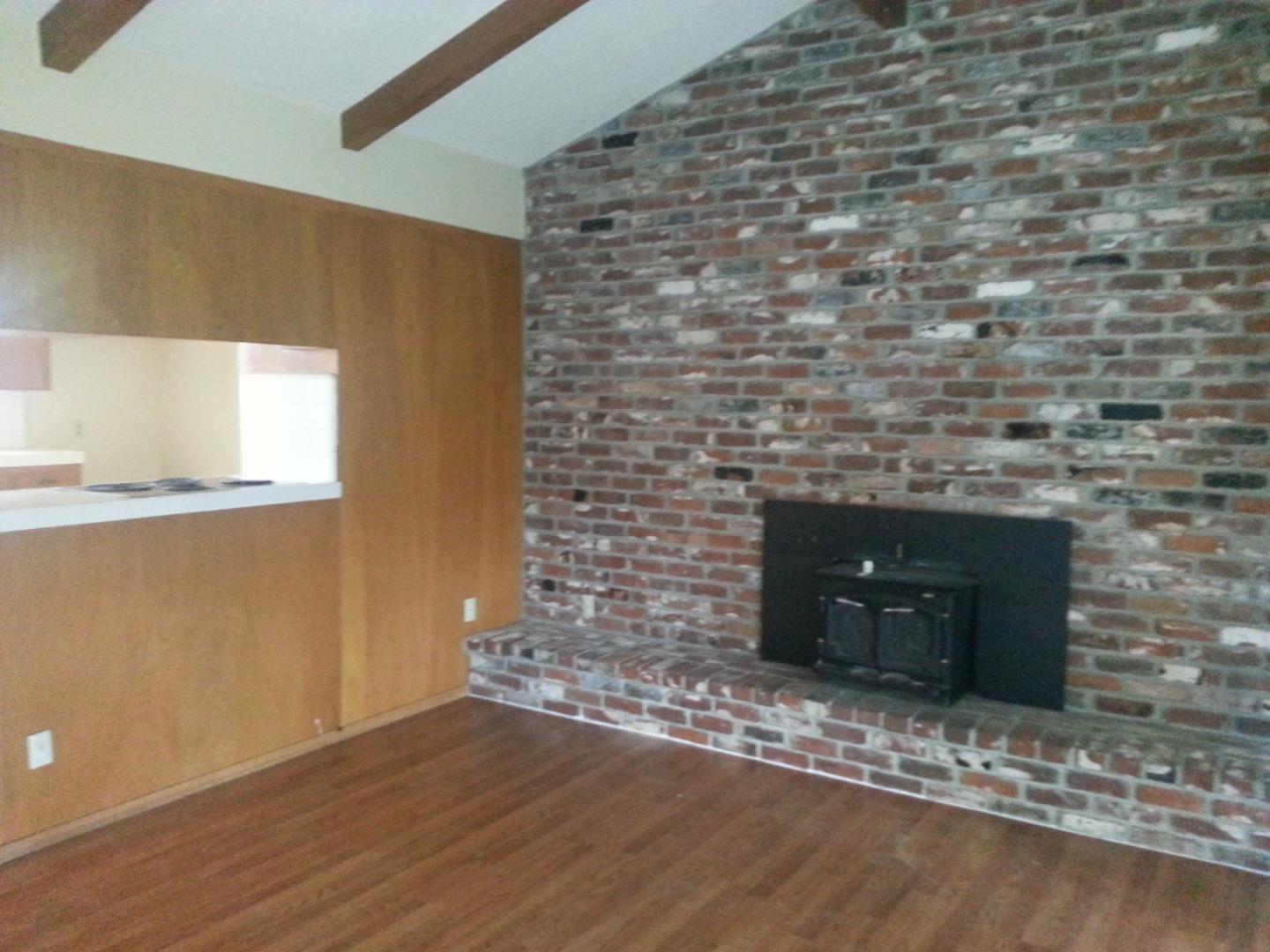856 Modoc Street Merced, CA 95340 - Photo 8 of 16 a room with a wooden floor and a fireplace