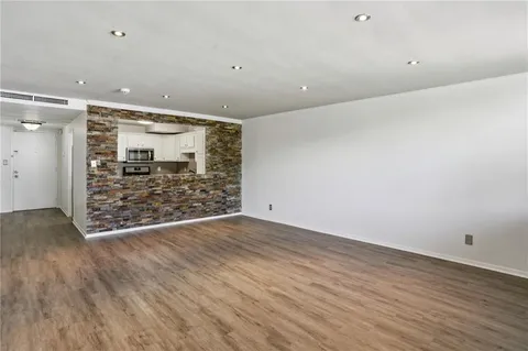 an empty room with wooden floor and entryway