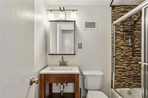 a bathroom with a toilet a sink and mirror