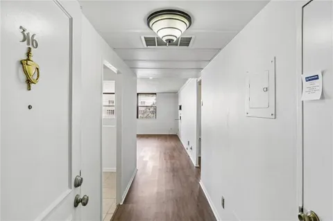 a view of a hallway with wooden floor