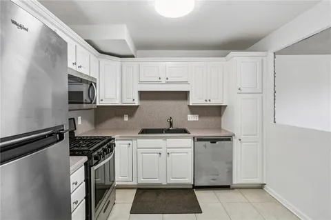 a kitchen with stainless steel appliances granite countertop a stove and a refrigerator