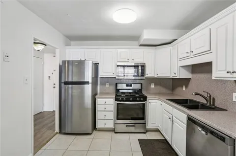 a kitchen with stainless steel appliances granite countertop a refrigerator sink and stove