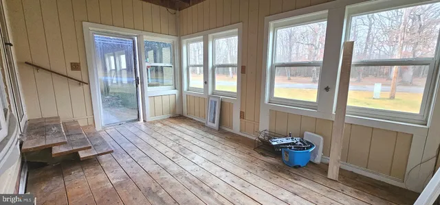 a view of a room that has a bed and wooden floor